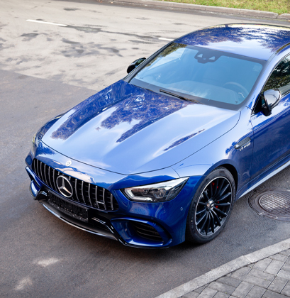 A blue car parked in a parking lot