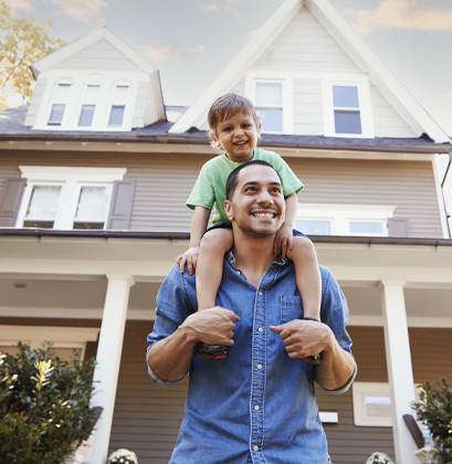 Father and son in front of their recently insured home