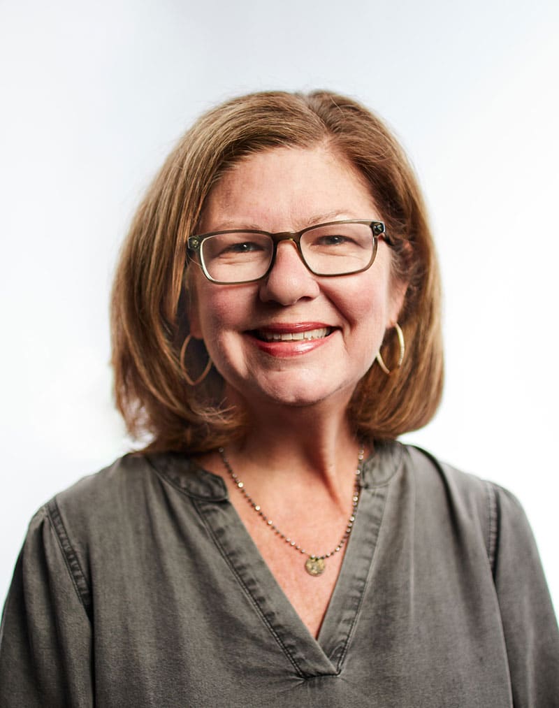 a person wearing glasses and smiling at the camera